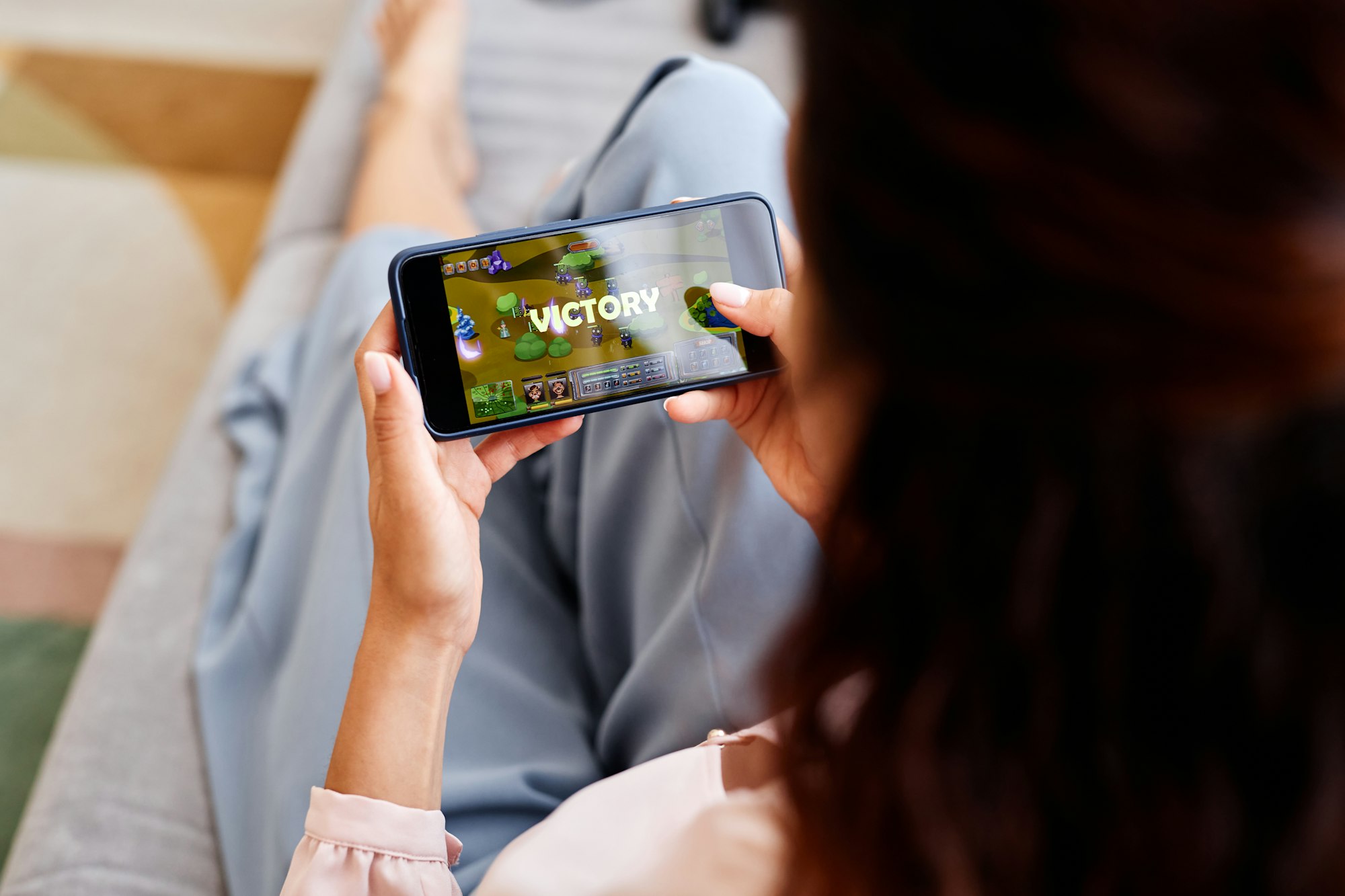 Close up of woman playing mobile game via smartphone